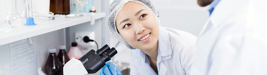 Education Division scientist smiling and microscope