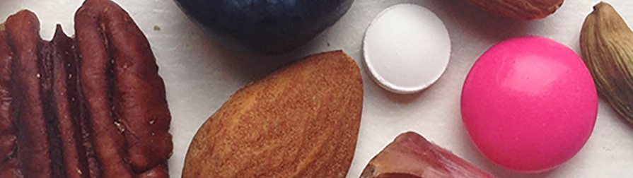 Nutraceutical Division close up on nuts and pill.
