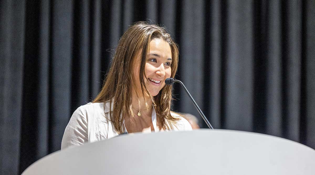 Student smiling and speaking at a podium at IFT FIRST