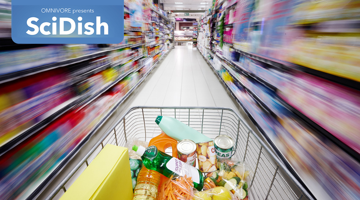 Shopping cart filled with grocery items moving through an aisle of a supermarket. Omnivore Present SciDish podcast logo tag